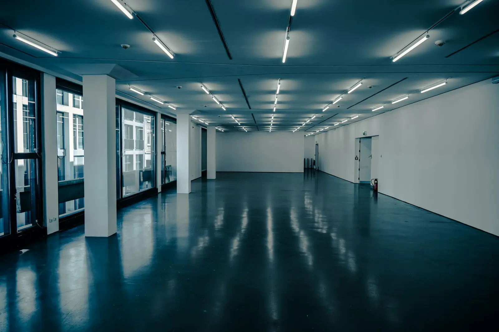Open office floor with polished concrete reflecting the ceiling lights
