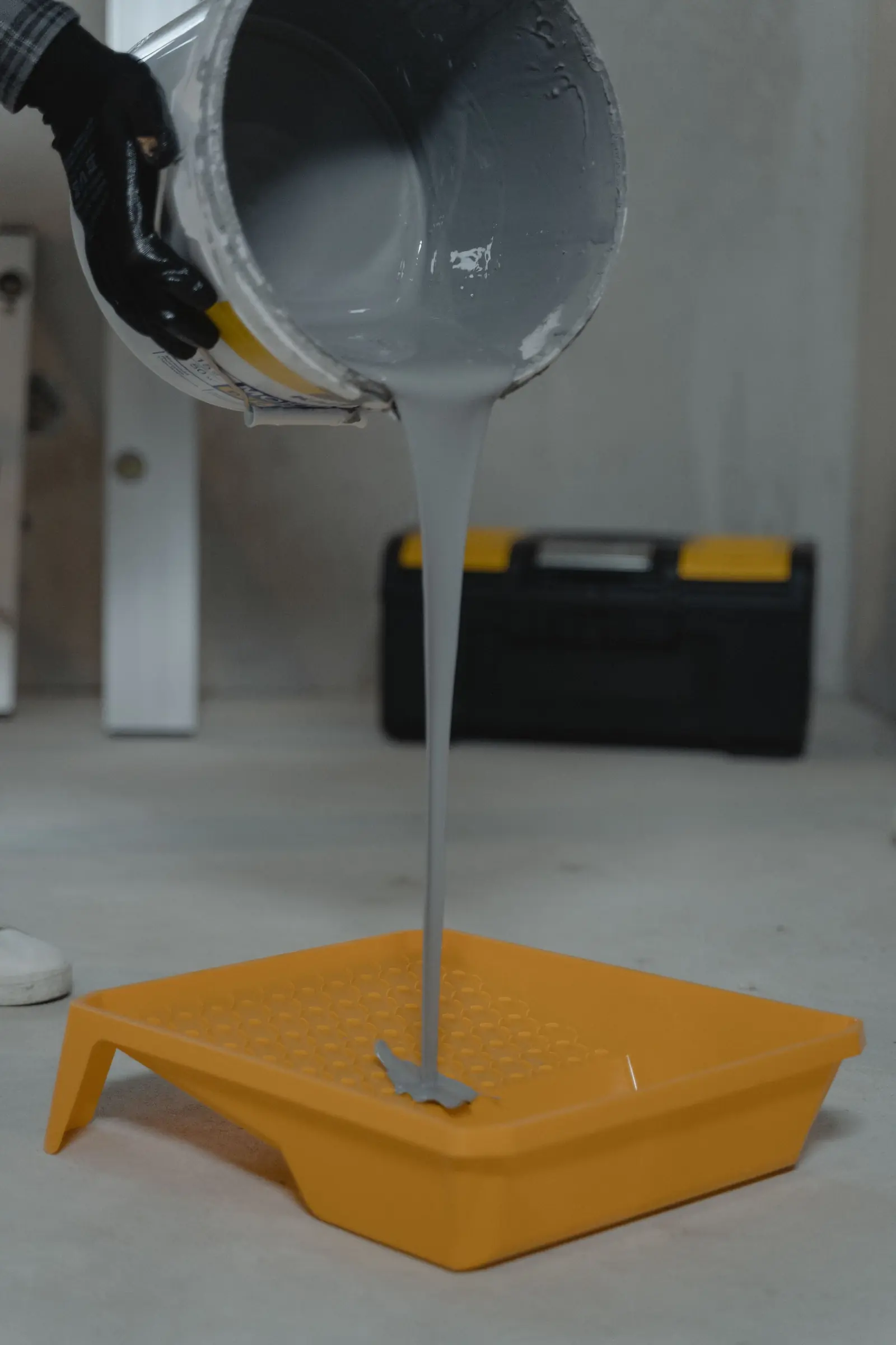Grey resin being poured into a roller tray
